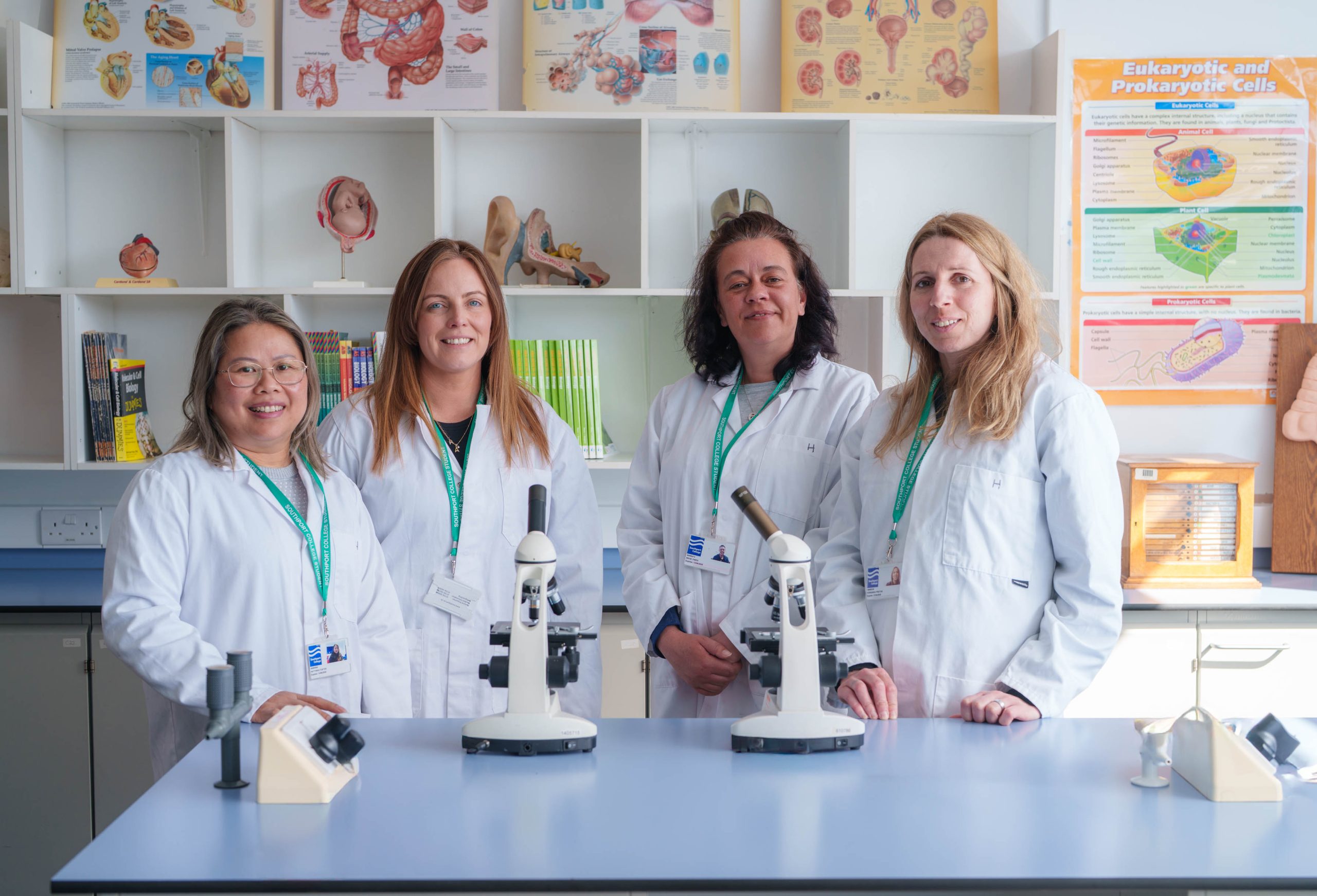 the Southport College team in there current lab. 4 women wearing lab coats standing in a lab.